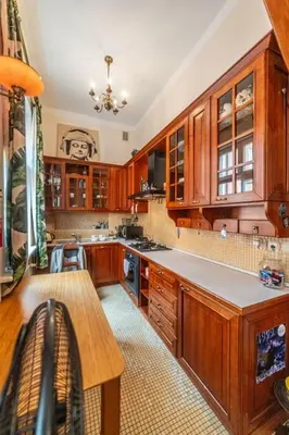 a large kitchen with wooden cabinets and a table at Climatic studio for 2-4 person in Main Square in Kraków