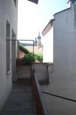 a walkway between two buildings with plants on the side at Climatic studio for 2-4 person in Main Square in Kraków