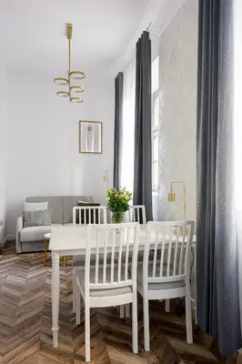 a white dining room with a white table and chairs at Native Apartments Smoleńsk 33 in Kraków