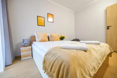 a bedroom with two beds and a yellow blanket at Moonlight by Housine in Zator