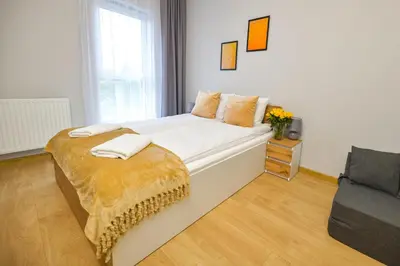 a bedroom with a large bed with a yellow blanket on it at Moonlight by Housine in Zator
