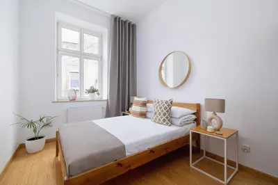 a white bedroom with a bed and a mirror at Wielopole 7 - 1 bedroom - OLD TOWN in Kraków