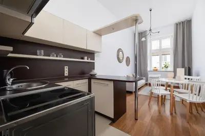 a kitchen with a sink and a table with chairs at Wielopole 7 - 1 bedroom - OLD TOWN in Kraków