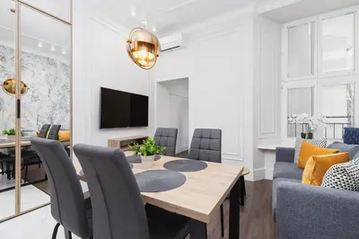 a dining room and living room with a table and chairs at Apartment with balcony - Kazimierz- Starowislna 43 in Kraków
