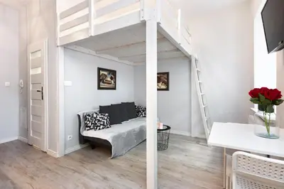 a living room with a loft bed and a couch at Pawia Apartments Studio in Kraków