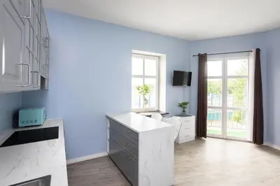 a kitchen with blue walls and a white counter at Pawia Apartments Studio in Kraków