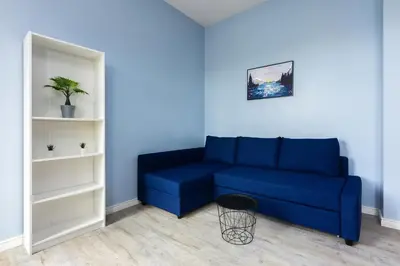 a blue couch sitting in a living room at Pawia Apartments Studio in Kraków