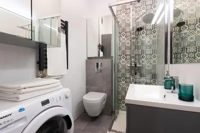 a bathroom with a washing machine and a sink at Pawia Apartments Studio in Kraków