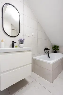 a white bathroom with a sink and a mirror at Apartment Close to the Center in Kraków