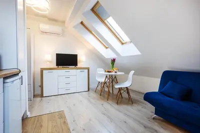 a living room with a blue couch and a table at Apartment Close to the Center in Kraków