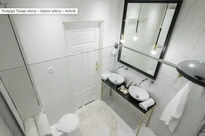 a white bathroom with a sink and a mirror at Jozefa 20 Street 2 bedroom apartment in Kraków