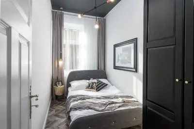 a small room with a bed and a window at Jozefa 20 Street 2 bedroom apartment in Kraków