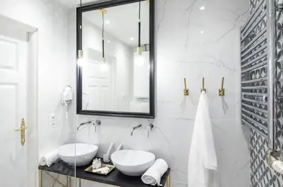 a white bathroom with two sinks and a mirror at Jozefa 20 Street 2 bedroom apartment in Kraków