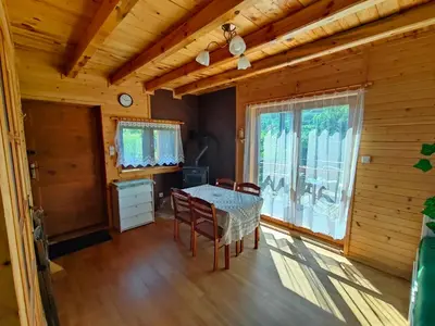 a dining room with a table and chairs and a window at Domek na Grządce in Bieńkówka