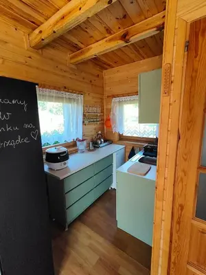 a kitchen with a stove and a refrigerator in a cabin at Domek na Grządce in Bieńkówka