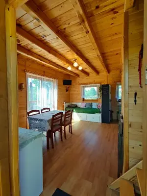 a dining room and kitchen in a log cabin at Domek na Grządce in Bieńkówka