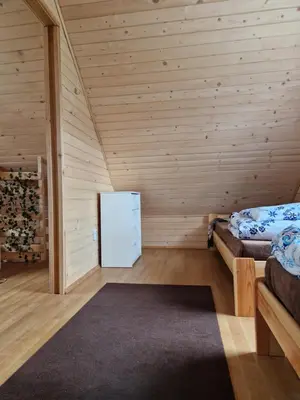 a room with two beds and a refrigerator at Domek na Grządce in Bieńkówka