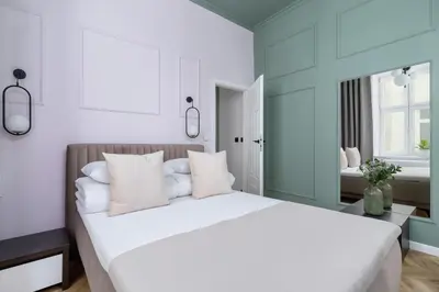 a bedroom with a large bed with white pillows at 3 Bedroom Apartment - Dietla 11 in Kraków