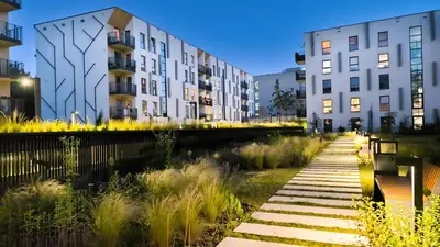 a row of buildings in a city at night at Lema Tauron Arena Two Bedroom Apartment in Kraków