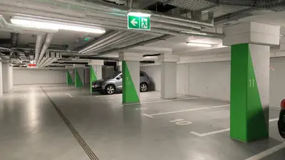 a parking garage with a car parked in it at Lema Tauron Arena Two Bedroom Apartment in Kraków