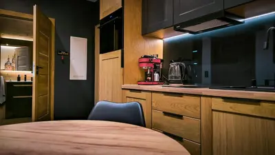 a kitchen with a table and a chair in it at Lema Tauron Arena Two Bedroom Apartment in Kraków