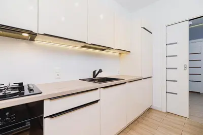 a kitchen with white cabinets and a sink at Dajwór 20 - Dzielnica Żydowska in Kraków