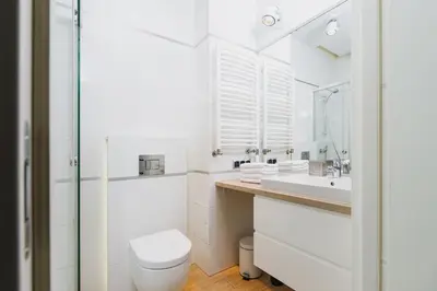 a white bathroom with a toilet and a sink at Dajwór 20 - Dzielnica Żydowska in Kraków