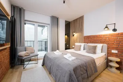 a bedroom with a bed and a brick wall at Horizon Apartments Na Dołach - Luxury Apartments near the Vistula River in Kraków