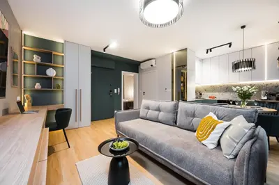a living room with a couch and a kitchen at Horizon Apartments Na Dołach - Luxury Apartments near the Vistula River in Kraków