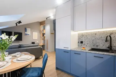 a kitchen and living room with a table and a couch at Horizon Apartments Na Dołach - Luxury Apartments near the Vistula River in Kraków