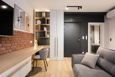 a living room with a couch and a brick wall at Horizon Apartments Na Dołach - Luxury Apartments near the Vistula River in Kraków