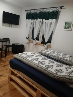 a bedroom with a bed and a television and a window at Stylove Apartamenty in Kocierz Rychwałdzki