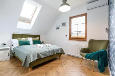 a bedroom with a bed with two stuffed animals on it at Green Door in Oświęcim