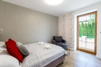 a bedroom with a bed and a chair and a window at Green Door in Oświęcim