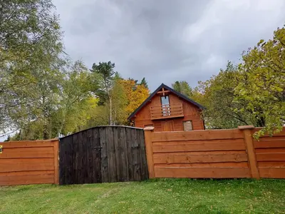 a wooden fence in front of a house with a gate at DOMEK NA GRANICY wynajem nocleg in Stankowa