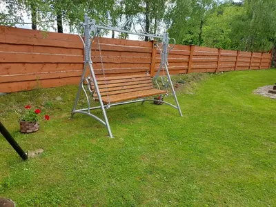 a bench in a yard next to a fence at DOMEK NA GRANICY wynajem nocleg in Stankowa