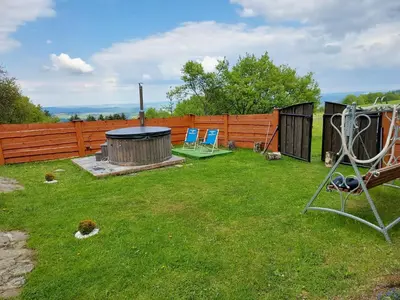 a backyard with two chairs and a fire pit at DOMEK NA GRANICY wynajem nocleg in Stankowa