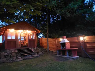 a small cabin with lights on the side of a fence at DOMEK NA GRANICY wynajem nocleg in Stankowa