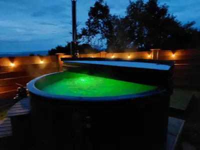 a hot tub with green water in a backyard at night at DOMEK NA GRANICY wynajem nocleg in Stankowa