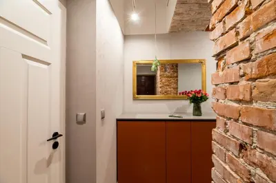 a kitchen with a brick wall and a mirror at Quiet Luxury on Floriańska in Kraków