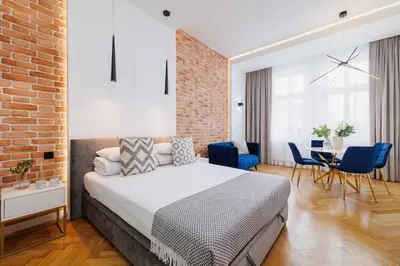 a bedroom with a bed and a brick wall at Kazimierz District - Dietla 21 street in Kraków