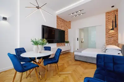 a living room with a table and chairs and a bed at Kazimierz District - Dietla 21 street in Kraków