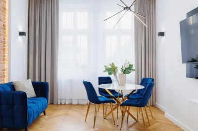 a living room with a table and blue chairs at Kazimierz District - Dietla 21 street in Kraków