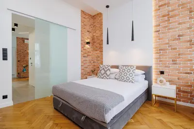 a bedroom with a bed with a brick wall at Kazimierz District - Dietla 21 street in Kraków