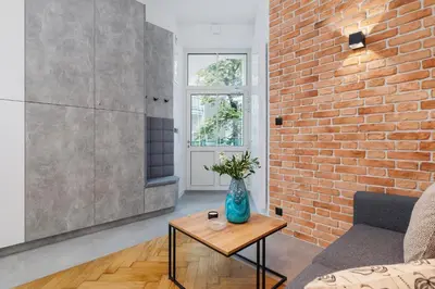 a living room with a brick wall and a vase on a table at Kazimierz District - Dietla 21 street in Kraków
