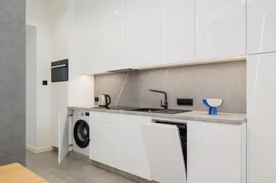 a kitchen with white cabinets and a sink at Kazimierz District - Dietla 21 street in Kraków