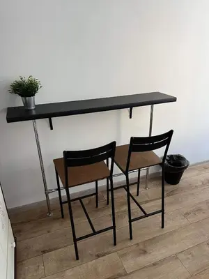 a black table with two chairs and a plant on it at Well Apartment in Old Town in Kraków