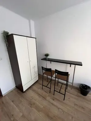 a table and two chairs and a cabinet in a room at Well Apartment in Old Town in Kraków