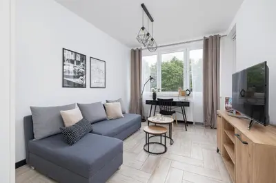 a living room with a couch and a table at Eklsuzywny Apartament z Parkingiem w Krakowie by Renters Prestige in Kraków