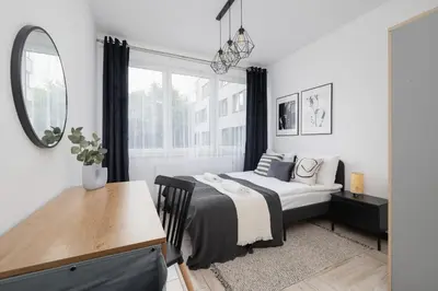 a bedroom with a bed and a desk and a mirror at Eklsuzywny Apartament z Parkingiem w Krakowie by Renters Prestige in Kraków